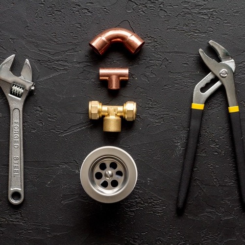 plumbers tools laying on a black table