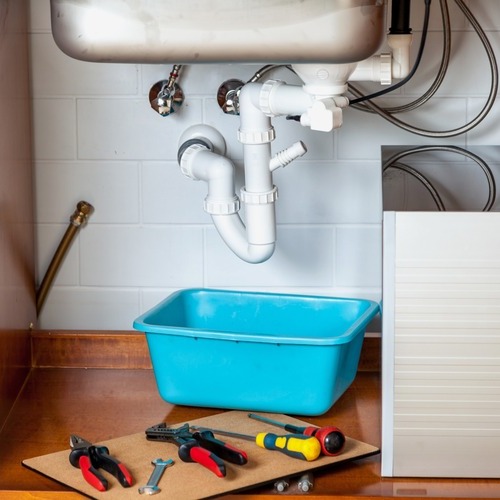 plumbers tools under a kitchen sink